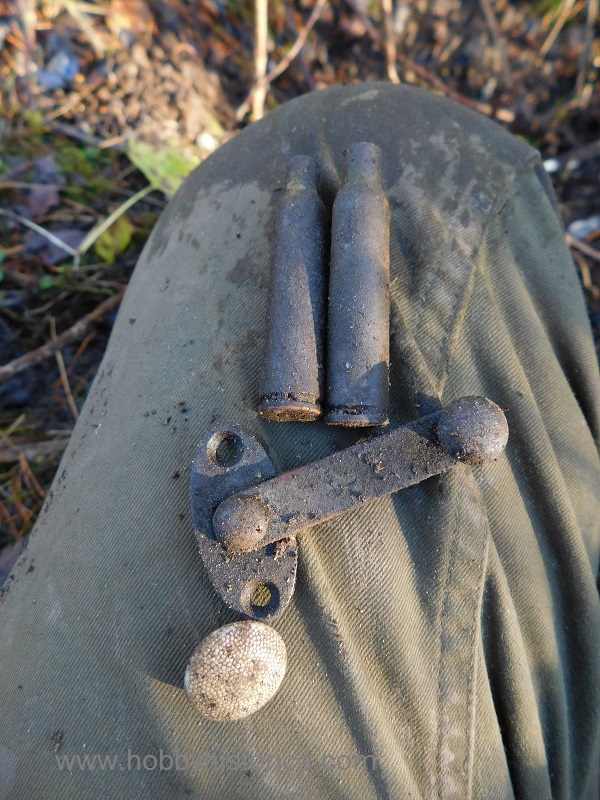 Two k98 casings, a clasp, and a button.
